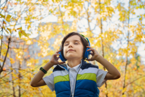 Junge hört mit Kinderkopfhörern Musik