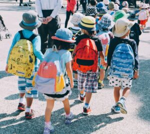 Kinder mit einem Rucksack laufen