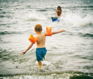 Kind mit Schwimmflügel im Meer