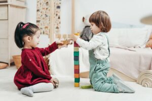 Zwei Kinder die mit Holzspielzeug spielen