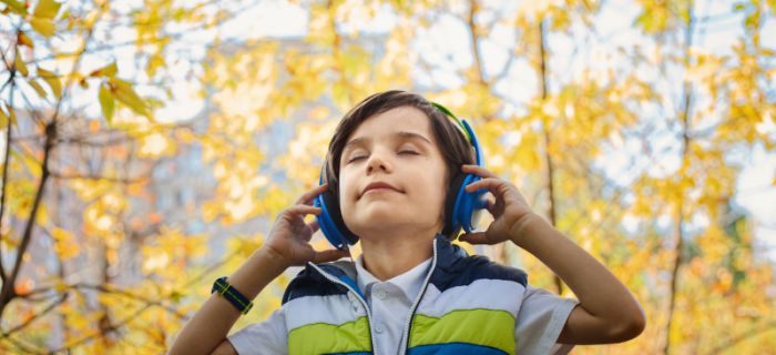 Junge hört mit Kinderkopfhörern Musik