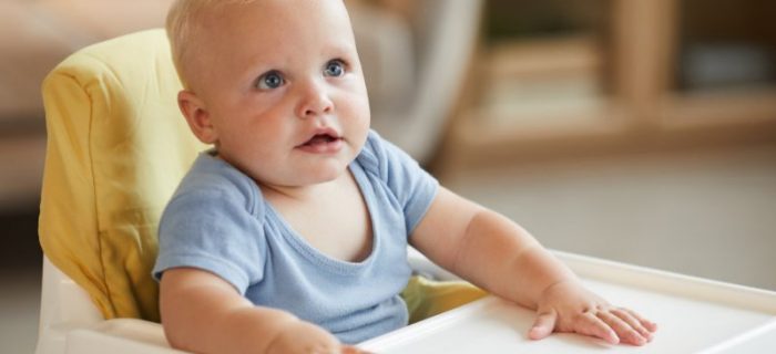 Kleinkind sitzt im Kinderhochstuhl.