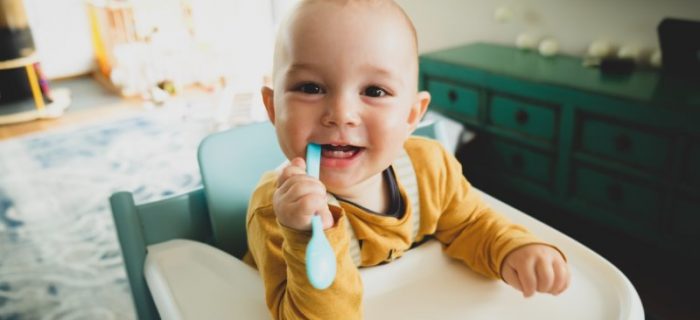 Baby mit Löffel im Mund