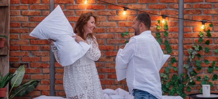 Paar macht eine Kissenschlacht mit Kopfkissen