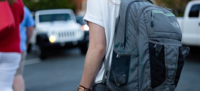 Mädchen mit Schulrucksack im Straßenverkehr