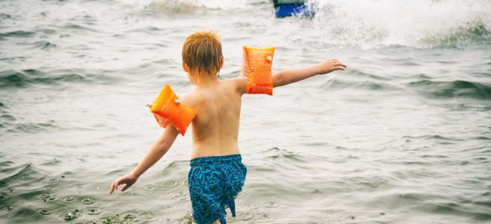 Kind mit Schwimmflügel im Meer